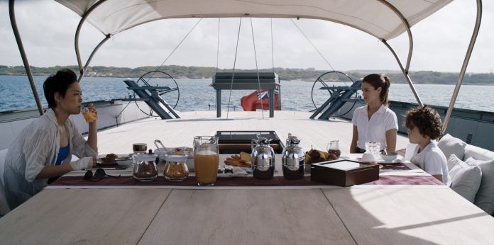 Donna, ragazza, bambino fanno colazione in barca a vela
